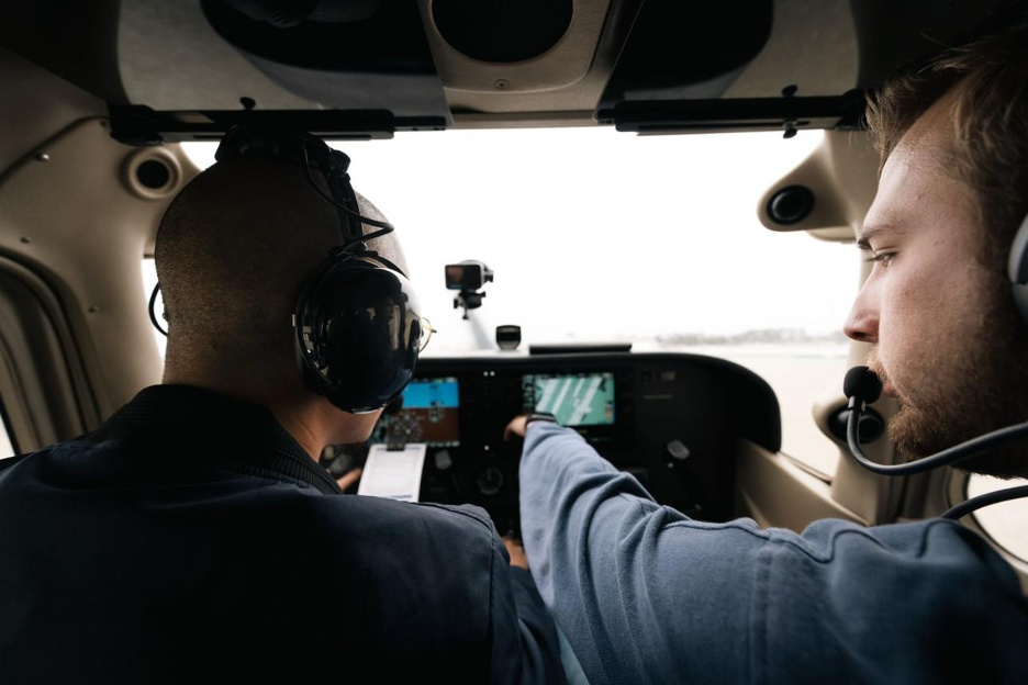 A flight instructor and student studying the panel together.
