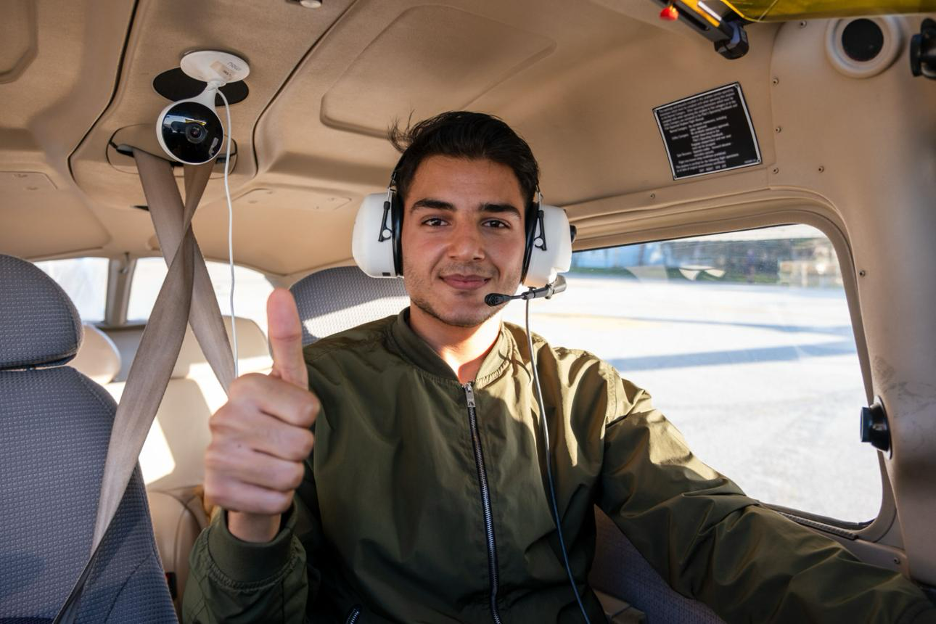 A new private pilot giving a thumbs up after their checkride.