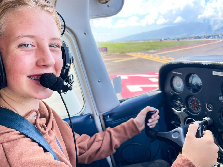 A new flyer in the cockpit, smiling at the runway view.